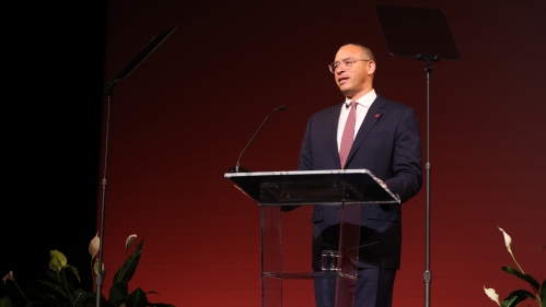 President Jonathan Holloway standing at Podium with red background