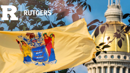 New Jersey state flag waving in the foreground with the golden dome of the New Jersey State House visible in the background. The flag features the state’s coat of arms and the motto 'Liberty and Prosperity – 1776.' A white 'R' logo and 'Rutgers' text appear in the upper left corner, symbolizing Rutgers University's connection to the state.