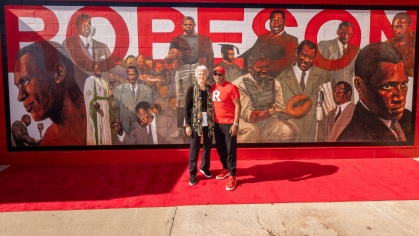 aul Robeson’s granddaughter, Susan Robeson, with Rutgers alumnus and artist Alonzo Adams in front of the mural unveiled in SHI Stadium.