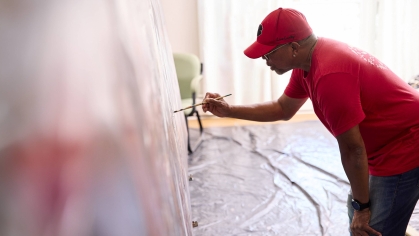 Alonzo Adams painting mural of Paul Robeson in August 2024