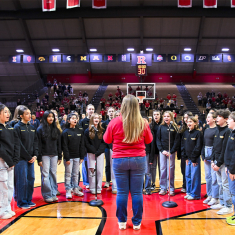 Bernadette conducts Bel Canto choir at a Rutgers women's basketball game last year.