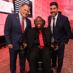 From left, Rutgers Football Head Coach Greg Schiano, LeGrand, and Marco Battaglia, a Rutgers alumnus and retired NFL player