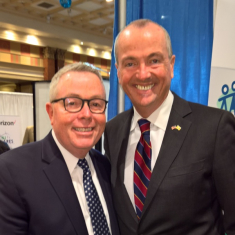 Rhodes with former Governor Phil Murphy.