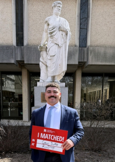 Benton with the RWJMS Hippocrates statue on Match Day.