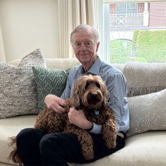 Cullen with his daughter’s dog Mango, a labradoodle. Photo By Allison Freeman.